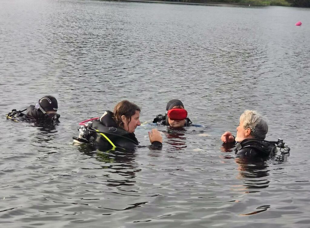 Plongeur accompagné sous l’eau dans une approche de plongée adaptée, attentive et sécurisée